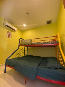 Bagan SeraiにあるMAMA homestayの黄色い壁のベッドルーム1室(二段ベッド2組付)