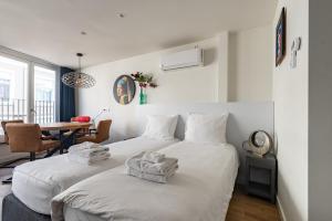 ブレダにあるStylish apartments in the heart of Breda city centerのテーブル付きの小さな部屋のベッド2台
