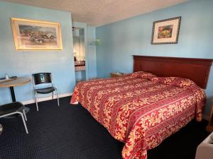 a hotel room with a bed and a table at Deluxe Inn LA in Los Angeles