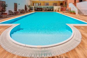 a swimming pool with blue water in a building at Apartments with swimming pool in Santa Teresa di Gallura in Santa Teresa Gallura