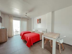 プラヤ・デ・ラス・アメリカスにあるStudios CC Victoria Ocean Viewのベッドルーム1室(ベッド2台、テーブル、窓付)