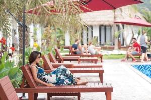 Kobieta leżąca na ławce przy basenie w obiekcie Vang Vieng Savanh Sunset View Resort w mieście Vang Vieng