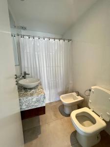 a bathroom with a white toilet and a sink at Roca Trust II Semipiso de 3 ambientes para 4 personas en zona güemes con cochera in Mar del Plata