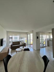 una sala de estar con una gran mesa de madera y sillas en Roca Trust II Semipiso de 3 ambientes para 4 personas en zona güemes con cochera en Mar del Plata