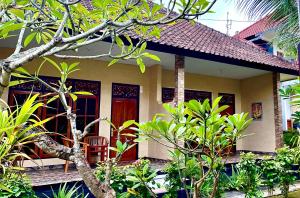 uma casa com uma cadeira em frente em Lembongan Tropical Guesthouse em Nusa Lembongan