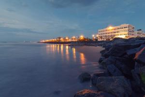 a building on the shore of the water at night at La Villa Pondi Chérie CenterTownBeachAuroville in Pondicherry