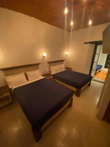 a bedroom with two beds and a window at Cuarto Casa Alebrije in Valle de Bravo