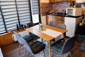 a kitchen with a wooden table and chairs in a kitchen at Coliba la Valle in Petroşani