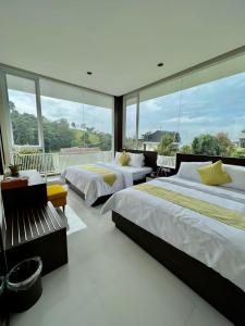 a bedroom with two beds and a large window at Platinum Yellow Bandung Villa 24 Pax Private Pool in Bengkok