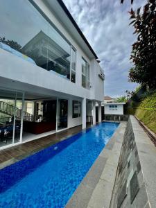 a swimming pool in front of a house at Platinum Yellow Bandung Villa 24 Pax Private Pool in Bengkok