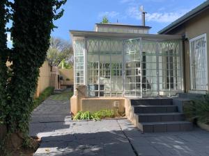 a house with a glass greenhouse on the front of it at Cheerful 3-bedroom home indoor & outdoor fireplace in Johannesburg