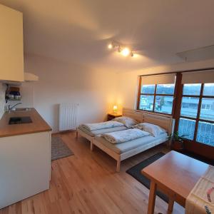 uma sala de estar com uma cama e uma cozinha em Apartments ChezTom Nenzing em Nenzing