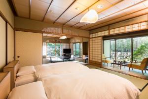 a bedroom with a large bed and a living room at Sanyo-so in Izunokuni
