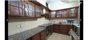a kitchen with wooden cabinets and a counter top at royal cottage guest house in Islamabad