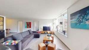 een woonkamer met een bank en een tv bij Family Apartment Sot Lantsch-Lenzerheide for 6 persons in Lenz