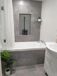 a bathroom with a bath tub and a sink at Heinlen on Bridges Street in Mount Gambier