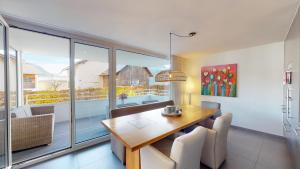 een eetkamer met een tafel en een groot raam bij Family Apartment Sot Lantsch-Lenzerheide for 6 persons in Lenz