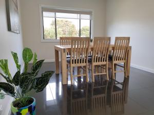 a dining room table with four chairs and a potted plant at Heinlen on Bridges Street in Mount Gambier
