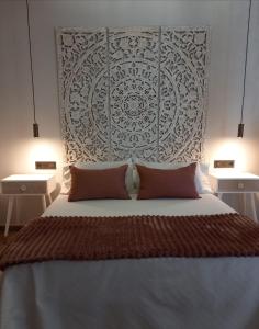 a bedroom with a large bed with two pillows at Suite con Jacuzzi de la Haya, junto al Teatro Romano in Merida