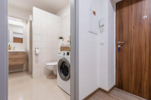 uma casa de banho com uma máquina de lavar roupa e um WC em Romantický LOFT parking u hlavního nádraží em Olomouc