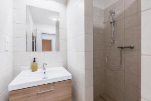 a white bathroom with a sink and a shower at Romantický LOFT parking u hlavního nádraží in Olomouc