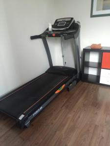 a treadmill in a room with a wooden floor at etage met slaap, en badkamer in Sommelsdijk
