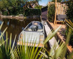 a small boat is parked in a canal at LODGE & LOFT in Sassenheim