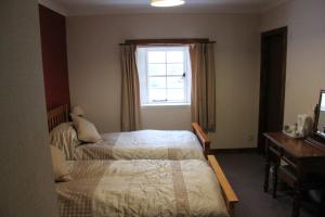 um quarto com 2 camas e uma janela em Craignure Inn em Craignure