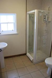 uma casa de banho com um chuveiro, um WC e um lavatório. em Craignure Inn em Craignure