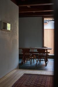mesa y sillas en una habitación con ventana en 滔々 日本郷土玩具館 蔵の宿 toutou, Gangukan Kura no Yado, en Kurashiki