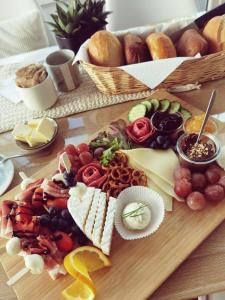 une planche à découper avec différents types de fromage et autres denrées alimentaires dans l'établissement Stedinger Landhotel & Café, à Berne