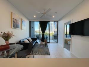 sala de estar con sofá y TV en Lovely 2 Beds Apt with City View at South Brisbane, en Brisbane