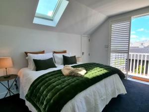 a bedroom with a green bed with a cat on it at The Greytown Loft in Greytown