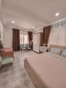 Un dormitorio con una cama grande y una sala de estar. en Lathong villa Đà Lạt, en Da Lat