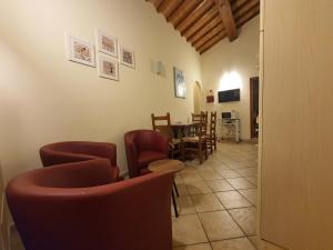 a waiting room with red chairs and a table at Appartamenti Tinacci in San Gimignano