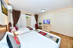 1 dormitorio con 2 camas y TV. en Sapa Symphony Hotel, en Sa Pa