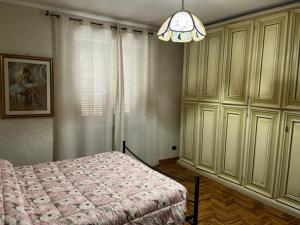 - une chambre avec un lit et un lustre dans l'établissement Villa Ines, à Ardea
