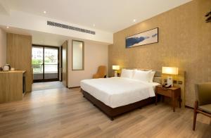 um quarto de hotel com uma cama e uma cadeira em Joyfultel em Guishan