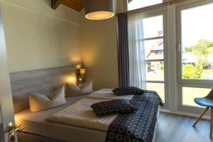 a bedroom with a bed with pillows and a window at An der Metow-Ferienpark Hotel in Plau am See