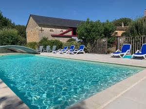 una piscina con tumbonas azules en un patio en La Jariette en Airvault