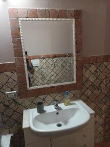 a bathroom with a sink and a mirror at VILLA ANNA in Casale la Cogna