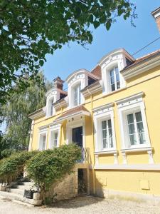 uma casa amarela com janelas brancas em Maison d'hôtes Au Cœur des Lacs em Lusigny-sur-Barse