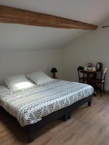 1 dormitorio con 1 cama y 1 mesa con sillas en Le Tamaris Chambres d'hôtes, en Sainte-Hermine