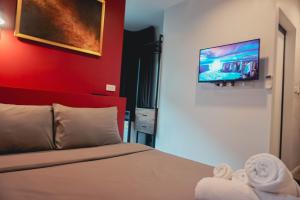 a bedroom with a bed and a tv on the wall at WiRE BANGKOK PRAKHANONG in Amphoe Phra Khanong