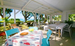 a dining room with a table and chairs at Villa Cap Malheureux in Cap Malheureux