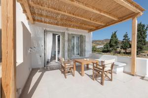 a dining room with a table and chairs on a balcony at Alisea Resort in Kimolos