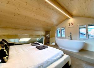 a bedroom with a large bed and a bath tub at beim Brunnen in Gsteigwiler