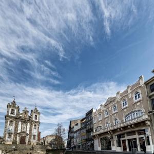a cloudy blue sky above buildings in a city at Moov Hotel Porto Centro in Porto