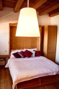 a bedroom with a bed with a large light above it at Residence Valpiccola in Val di Zoldo