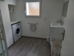 a white laundry room with a washing machine and a window at Citad' Yeu in Port-Joinville